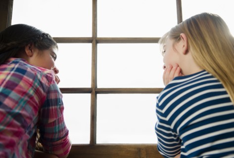 Two girls sitting by window. Photo : Jamie Grill
