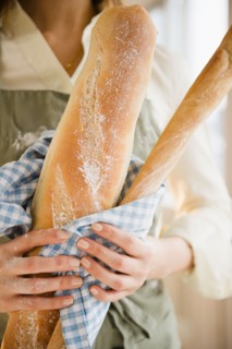 Close up of woman's hands holding baguette. Photo : Jamie Grill