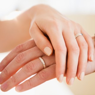 Close up of man's and woman's hands with wedding ring. Photo : Jamie Grill