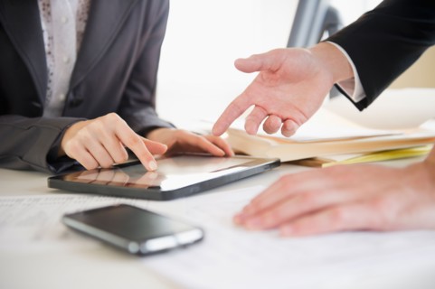 Close up of business people's hand working with digital tablet. Photo : Jamie Grill