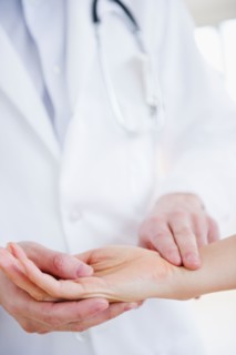 Close up of doctor taking patient's pulse. Photo : Jamie Grill
