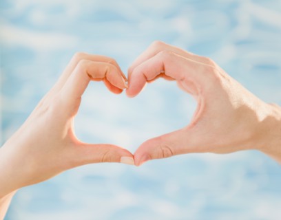 Close up of man's and woman's hands making heart shape, studio shot. Photo : Jamie Grill