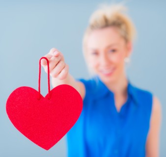 Close up of hand of young woman holding red heart, studio shot. Photo : Daniel Grill