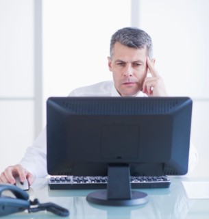 Portrait of businessman working at desk. Photo : Daniel Grill