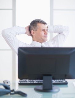 Portrait of businessman relaxing at desk. Photo : Daniel Grill