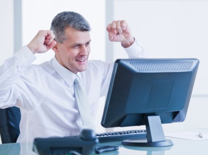 Portrait of happy businessman working at desk. Photo : Daniel Grill