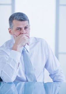 Portrait of businessman sitting at desk. Photo : Daniel Grill