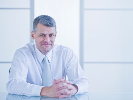 Portrait of businessman sitting at desk. Photo : Daniel Grill