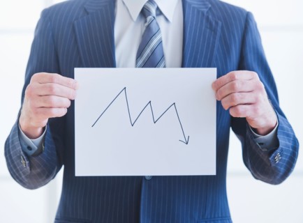 Man wearing suit holding chart. Photo : Daniel Grill