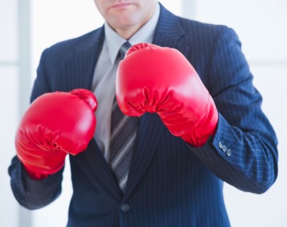 Businessman wearing red boxing gloves. Photo : Daniel Grill