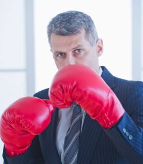 Businessman wearing red boxing gloves. Photo : Daniel Grill