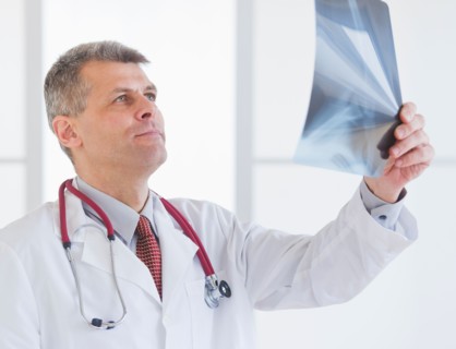 Portrait of doctor looking at x-ray image. Photo : Daniel Grill
