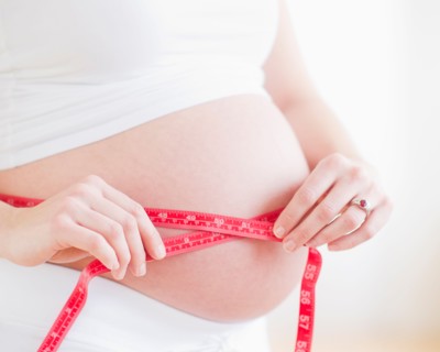 Pregnant woman measuring her belly. Photo : Daniel Grill
