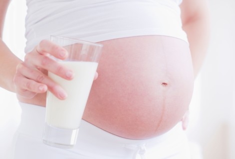 Pregnant woman with glass of milk. Photo : Daniel Grill