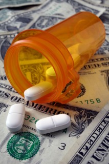 Studio shot of pill bottle and dollar banknotes. Photo : Winslow Productions