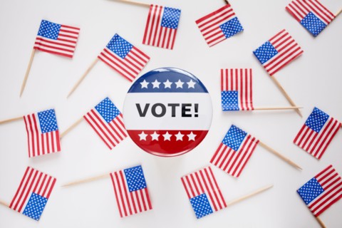 Studio shot of vote pin and small american flags. Photo : Winslow Productions