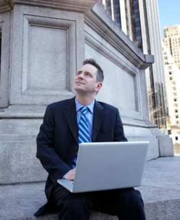 USA, New York, New York City. Portrait of businessman with laptop. Photo : Winslow Productions