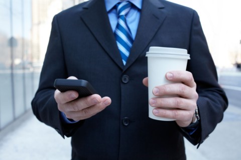 USA, New York, New York City. Businessman with smartphone and plastic cup. Photo : Winslow