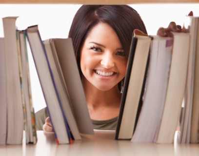 Portrait of young woman searching book on shelf. Photo : Mike Kemp