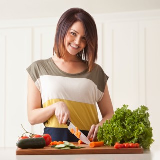 Young woman cutting vegetables. Photo : Mike Kemp