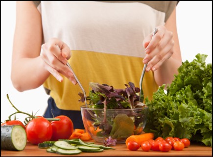 Young woman preparing salad. Photo : Mike Kemp