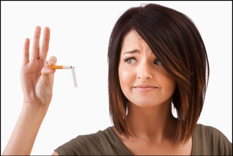 Young woman breaking cigarette. Photo : Mike Kemp