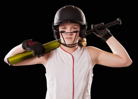 Portrait of girl (12-13) plying softball, studio shot. Photo : Mike Kemp