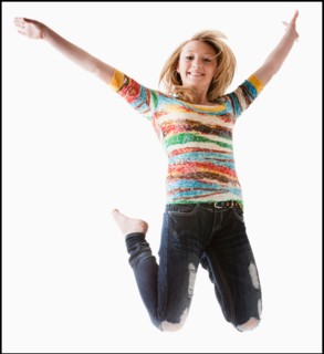 Studio shot of girl (12-13) jumping with arms raised. Photo : Mike Kemp