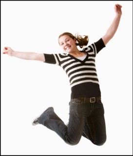 Studio shot of girl (12-13) jumping with arms raised. Photo : Mike Kemp