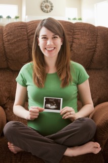 Portrait of pregnant woman showing ultrasonography scan. Photo : Mike Kemp