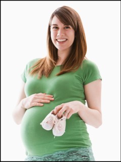 Studio Shot of woman holing baby booties. Photo : Mike Kemp