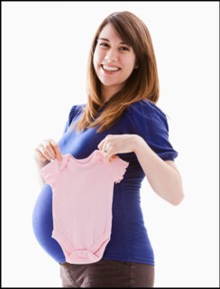 Studio Shot of woman holing baby pink onesie. Photo : Mike Kemp