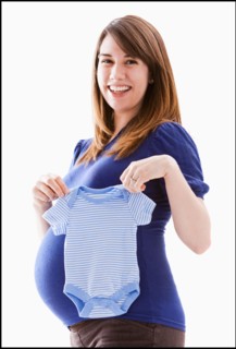 Studio Shot of woman holing baby blue onesie. Photo : Mike Kemp