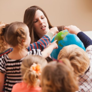 Teacher with children (2-3, 4-5) learning geography. Photo : Mike Kemp