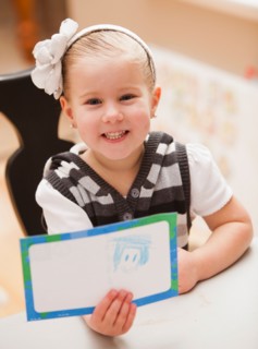 Girl (4-5) showing her drawing. Photo : Mike Kemp