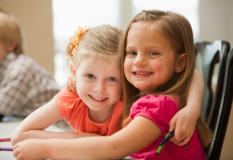 Portrait of girls (4-5)  looking at camera in kindergarten. Photo : Mike Kemp
