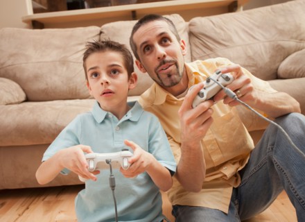 Front view of father and son (8-9) playing Video Games. Photo : Mike Kemp
