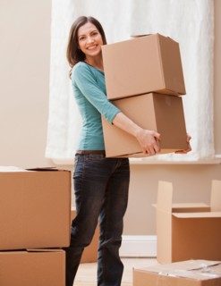 Mid adult woman carrying cardboard boxes. Photo : Mike Kemp