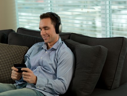 Man sitting on sofa listening music. Photo : Dan Bannister