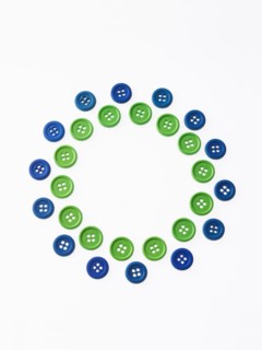 Studio shot of green and blue buttons arranged in circle. Photo : David Arky