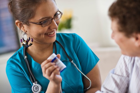 Young female nurse attending patient. Photo : Tim Pannell