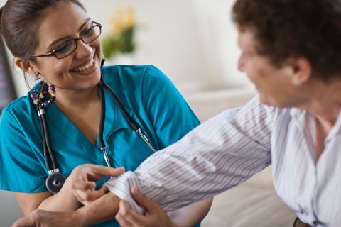 Young female nurse attending patient. Photo : Tim Pannell
