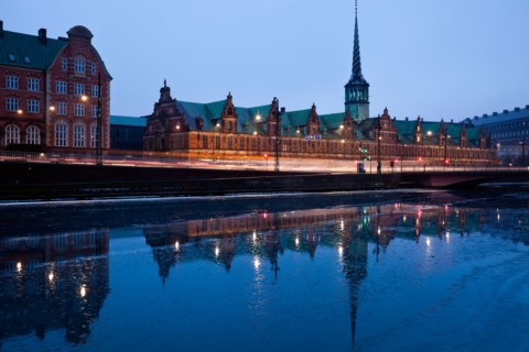 Denmark, Copenhagen. View over canal towards Copenhagen Stock Exchange and Christiansborg Castle.