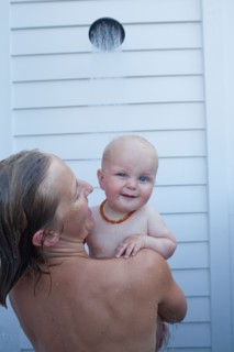 Mid adult woman having shower with her baby son (12-17 months) . Photo : Noah Clayton