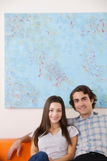 Portrait of young couple sitting on sofa. Photo : Rob Lewine