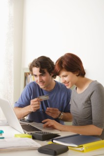 Young couple using laptop . Photo : Rob Lewine