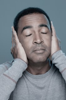 Studio shot of mature man covering ears. Photo : Rob Lewine