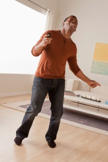 Mid adult man dancing at home. Photo : Rob Lewine
