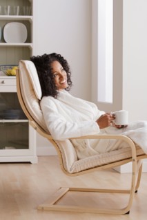 Woman drinking coffee in armchair in morning. Photo : Rob Lewine