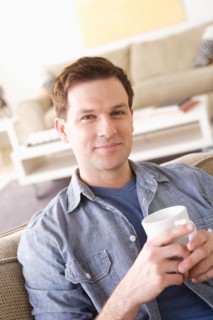 Portrait of smiling mid adult man holding mug. Photo : Rob Lewine